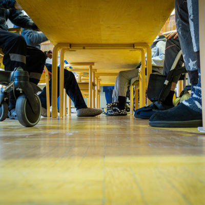 Bild av äldre personers fötter under ett bord på ett äldreboende. 