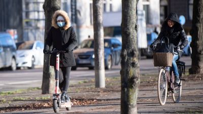 En person på elsparkcykel och en på vanlig cykel i Stockholm, Sverige.