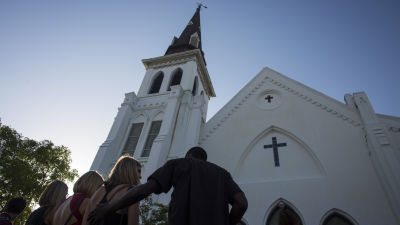 Folk tröstar varandra utanför den kyrka där skjutningen i Charleston ägde rum