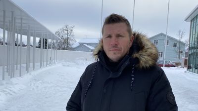 En man iklädd vinterjacka tittar med allvarlig min in i kameran. Miljön är snöig.