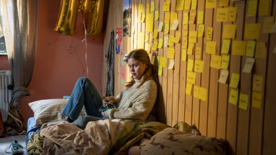 Mathilde (Andrea Heick Gadeberg) sitter på sängen i sitt rum och ser allvarlig ut.