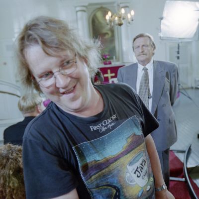 Ohjaaja Jukka Mäkinen työssään Mooseksen perintö -sarjan kuvauksissa vuonna 2001. Taustalla näyttelijä Matti Tuominen (roolinimi Urmas Hakkarainen). 
