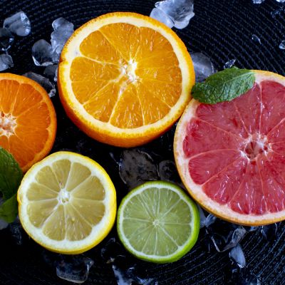 En bild på fem olika citrusfrukter skurna i halvor med insidan uppåt.