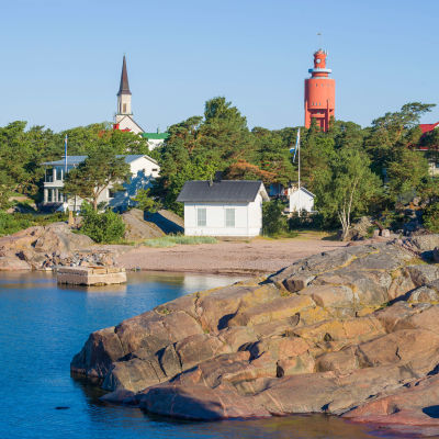 Vy av hav och strand i Hangö. I bild syns också Hangö vattentorn och kyrka.