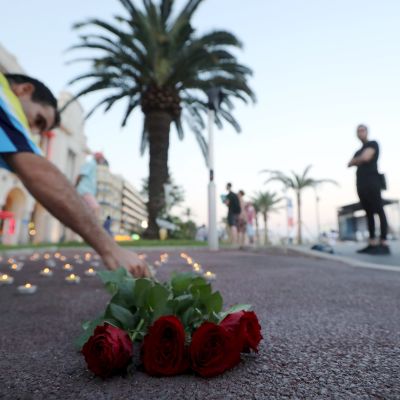 Man lägger ner vid rosor vid Promenade des Anglais i Nice den 14 juli 2017, där en förödande terrorattacken skedde ett år tidigare.