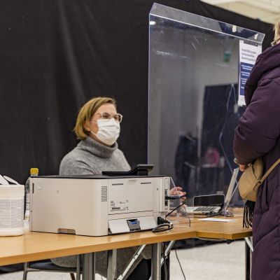Nainen käy palauttamassa ennakkoäänensä virkailijalle 2022 aluevaalien ennakkoäänestyksessä Torniossa.