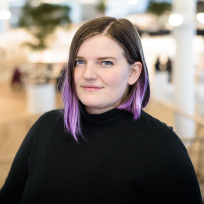 Julie Ebbe i en svart polotröja framför bokhyllorna på Ode.