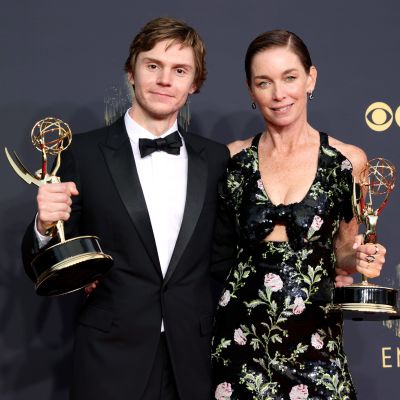 Evan Peters och Julianne Nicholson poserar med sina Emmystatyetter. Evan bär en svart kostym och svart fluga. Julianne har på sig en svart klänning med blommönster.
