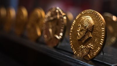 Nobelprismedaljer i närbild. På medaljen syns Alfred Nobel.