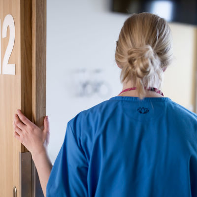 Sairaanhoitaja potilashuoneen ovella, Uusi lastensairaala, Helsinki, 8.7.2019.