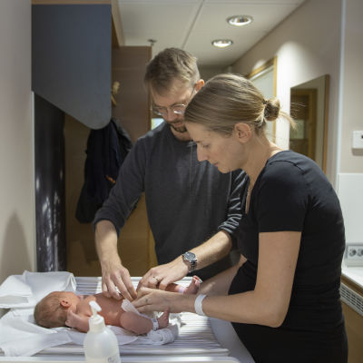 Sofia Tigerstedt och Jussi Ukkonen byter blöja på sin nyfödda dotter på patienthotellet Familjeboet i Helsingfors.