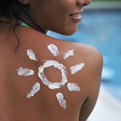En kvinna med solskyddsmedel på ryggen.
