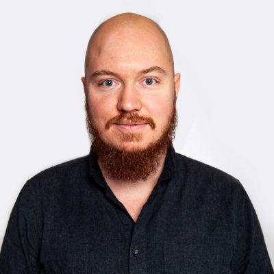 En närbild av en skallig man med rött skägg.