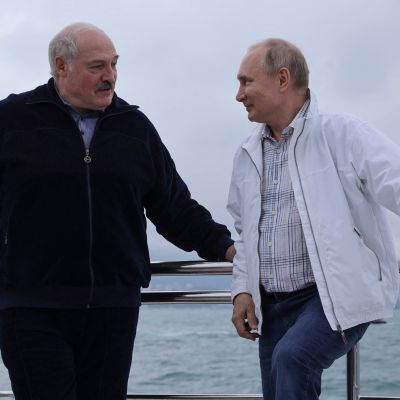 Aleksandr Lukasjenko och Vladimir Putin står på en båt och ler mot varandra. 