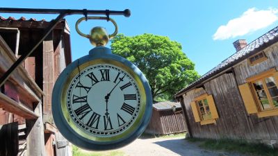 En klocka hänger utanför en vägg på Klosterbacken i Åbo.