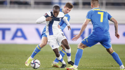 Glen Kamara har bollen i närkamp med två spelare från Ukraina.