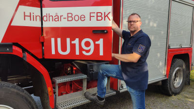 En man påväg in i en brandbil.