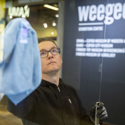 Käyttömestari Antti Schroderus puhdistaa suojapleksejä WeeGee-talossa.