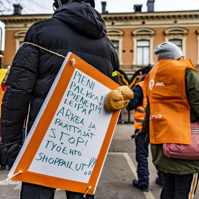 En skylt med text som kritiserar Åbobolaget Arkea under en demonstration i Åbo vintern 2021.  