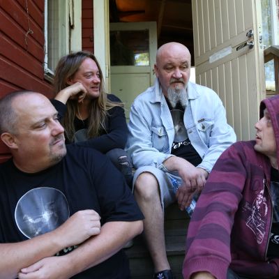 Bändin jäsenet istumassa treenikämpän portailla.