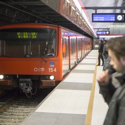 Ihmisiä ja metrojuna Matinkylän metroasemalla.