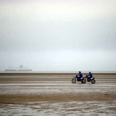 Poliisin moottoripyöräpartio ajoi rannalla Oye-Plagessa lähellä Calais'n satamaa Pohjois-Ranskassa 31. tammikuuta 2020. Tuolloin turvatoimia kiristettiin silloisen sisäministerin Christophe Castanerin vierailun takia.