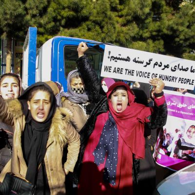 Afghanska kvinnor demonstrerar med plakat på en gata i Kabul. Texten på plakatet lyder: "Vi är det hungriga folkets röst".