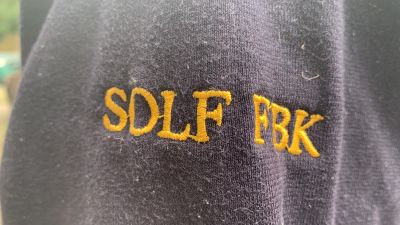 Ärmen på en mörkblå tröja där namnet Solf FBK står skrivet i gult.