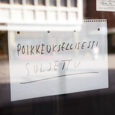 En handskriven lapp i ett fönster där det står "poikkeuksellisesti suljettu".