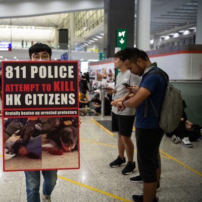 En demonstrant hålle rupp en plakat inne i flygplatsen i Hongkong.