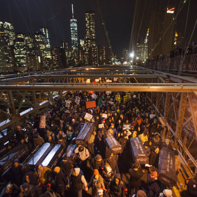 Demonstranter marscherar över Brooklyn Bridge i protest mot att en åtalsjury i New York beslutat att inget åtal kommer att väckas mot den polis som kvävde ihjäl den 43-årige Eric Garner sommaren 2014.