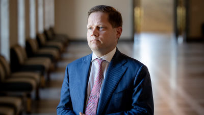 Markus Lohi står i riksdagens korridor och svarar på frågor.