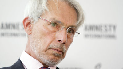 En bild av Heinz Patzelt. Grå skäggstubb, grått hår och glasögon.