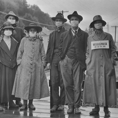 En grupp människor iförda munskydd under influensapandemin 1918