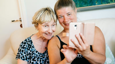Vanhempi ja nuorempi nainen ottavat yhdessä selfietä.