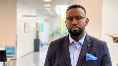 Abdullahi Sultan står i en korridor på Åbo kristliga institut.