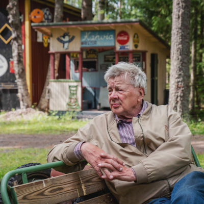 Matti Järvenpää istuu penkillä luomassaan Rautapuistossa.