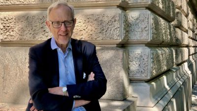Porträttbild av Thomas Wilhelmsson med korsade armar på bröstet, utanför Ständerhuset