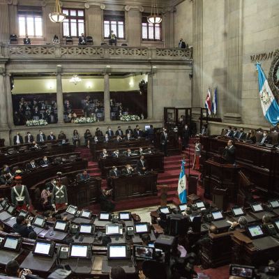 Guatemalan kongressin istuntosali. Presidentti puhuu puhujankorokkeella.