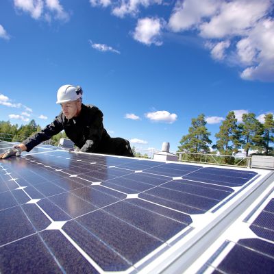 Forskningsassistenten Miguel Lavado installerar solpaneler på taket till Villmanstrands tekniska universitet