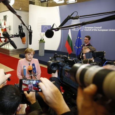 Tysklands förbundskansler Angela Merkel omringad av journalister i Bryssel.