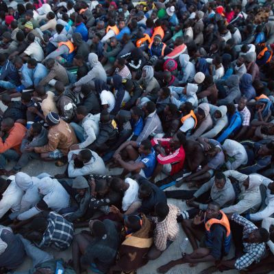 Flyktingar som den libyska kustbeavkningen har räddat ur Medelhavet väntar på att föras till interneringsläger