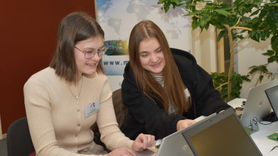 Två unga flickor jobbar vid en dator.
