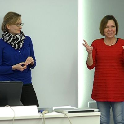 Kuurojen Liiton sanakirjatyöryhmän sanakirjantoimittaja Niina Lappalainen ja sanakirjatyöntekijä Pia Taalas esittelevät opetusmateriaalia.