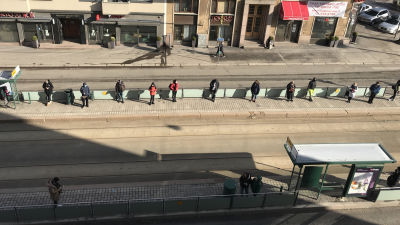folk på spårvagnshållplats håller distans
