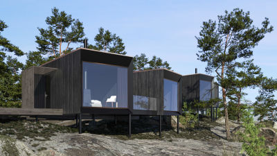Svarta hotellrum/fristående små byggnader uppe på ett berg. Väggen mot havet är av glas.