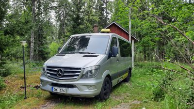 En stor taxibil parkerad på en gård.