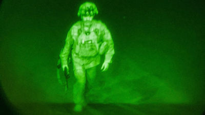 Den sista amerikanska soldaten i Afghanistan generalmajor Chris Dunahue stiger in i ett transportplan. Det är natt och bilden är tagen genom en mörkerlins.