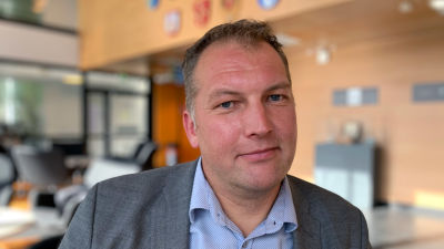 En man i kavaj och skjorta titar mot kameran