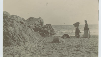 Kvinna fotograferar på stranden på Île Saint-Honorat i Cannes, sekelskiftet 1800-1900.